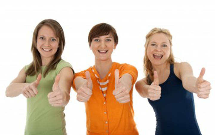 Three beautiful women cheering on their friend, building her confidence.