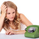 Attractive young woman awaits a phone call. wondering why he hasn't called.