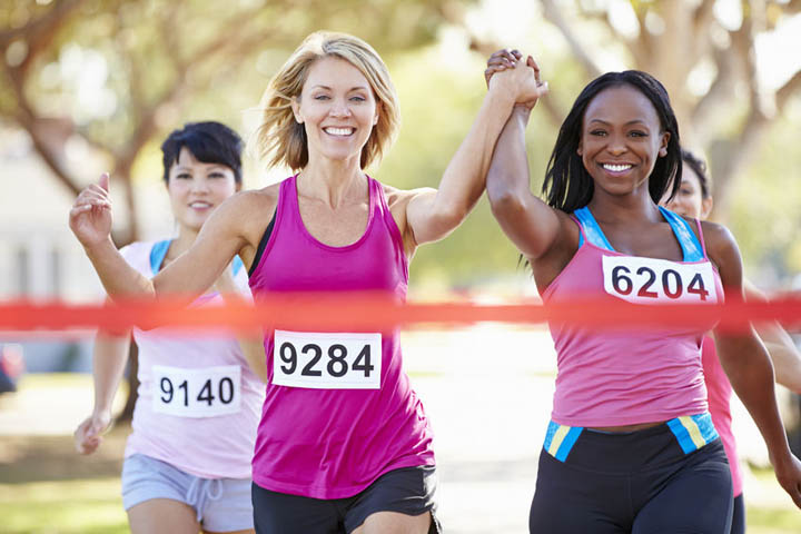 A group of beautiful women finishing a running race and supporting each other.