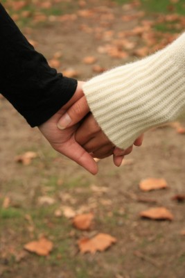 Real Love. Real Love never leaves you hanging. Real Love never leaves you guessing. Real love never hurts. A man and woman are holding hands walking through an autumnal field of fallen leaves.