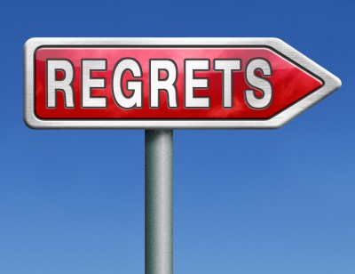 A large red sign against a background of blue sky reads: regrets.