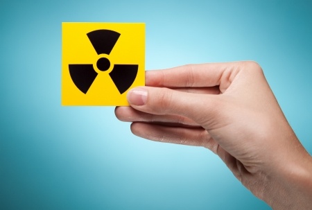 A woman's hand holds the symbol for radiation indicating that she feels like she is in a toxic relationship