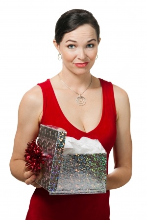 A beautiful woman in a red dress is disappointed as she opens a Christmas gift and realizes that is is not the ring signifying a commitment that she really wanted when she really wanted a committed relationship. 