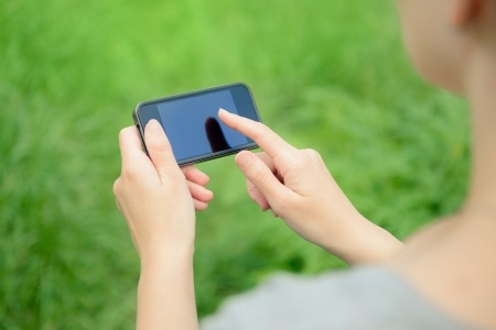 A woman is looking at her smartphone wondering why he stopped texting me every day, and wondering if she's being irrational because he stopped texting me.