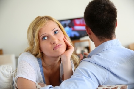 A beautiful blond woman is upset at her boyfriend because he won't commit, as he just watches TV and can't talk about it.