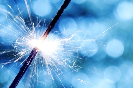 Image of a sparkler against a blue bokeh background representing the truth about the spark in a relationship.