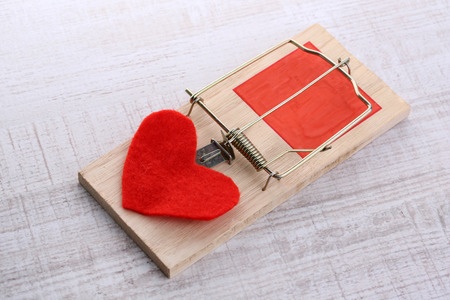 A mousetrap with a red felt heart representing the trap that many women fall into of comparing themselves to others.