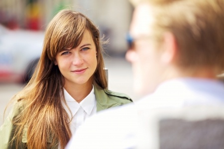 A beautiful woman is looking at her boyfriend with love wondering what is it about him?