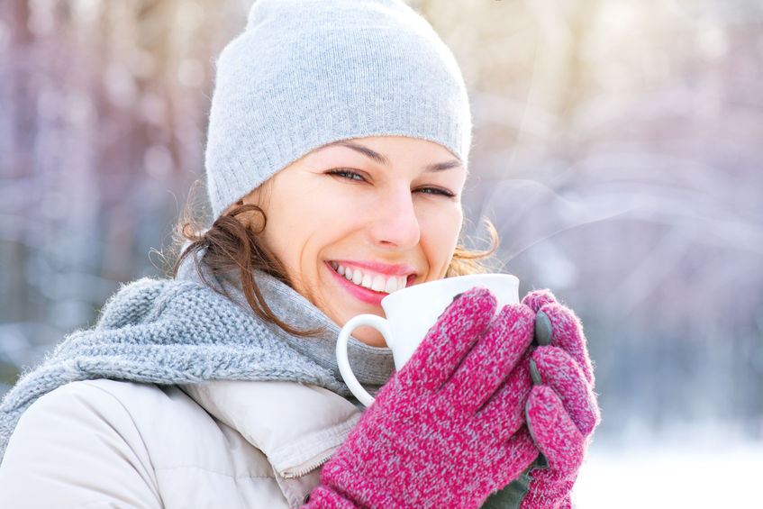 A beautiful woman is happy drinking  a cup of coffee on a winter day near Valentine's day.