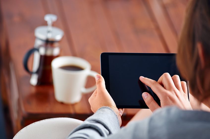 A woman is looking at her tablet reading a nasty email from her ex after a break up.