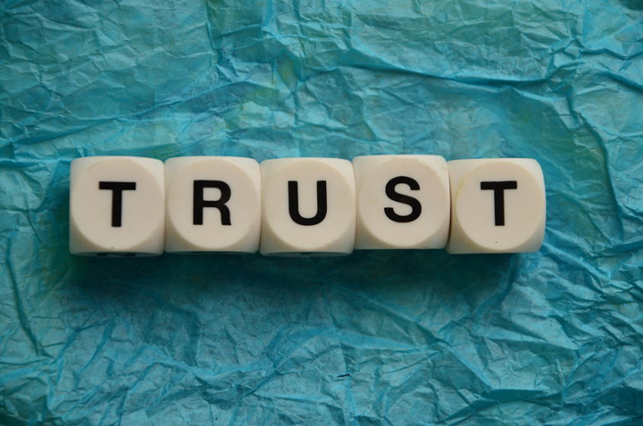 The word trust in letter blocks on tissue paper.