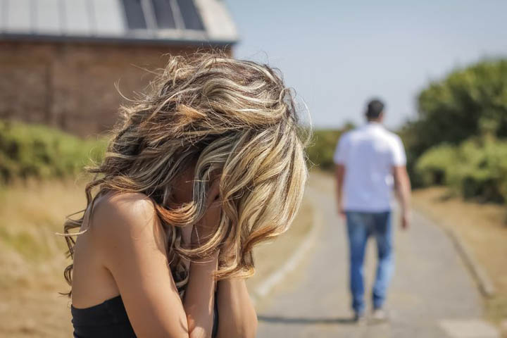 A woman has her head in her hands because her boyfriend has disappeared again.