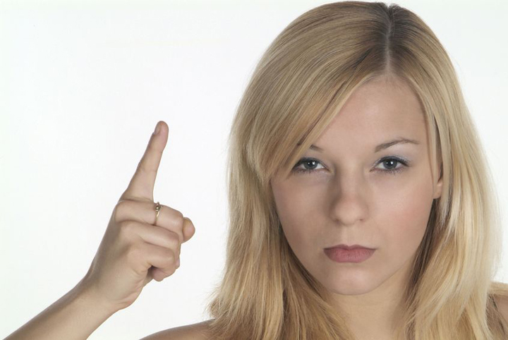 A beautiful blond woman is very upset with her boyfriend, and is shaking her finger.