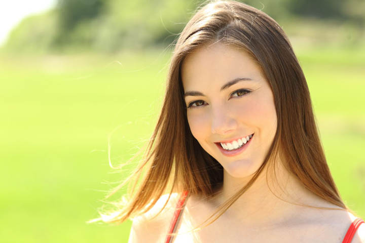 A beautiful woman smiling in a park.