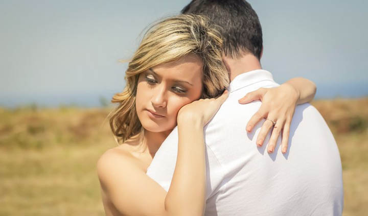 A beautiful woman is hugging her boyfriend, wondering why he's getting emotionally distant.