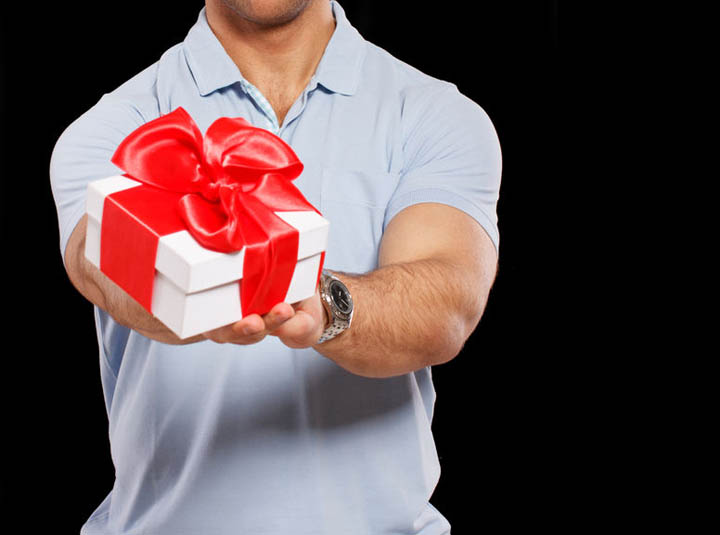 A nice guy is holding a gift for his girlfriend.