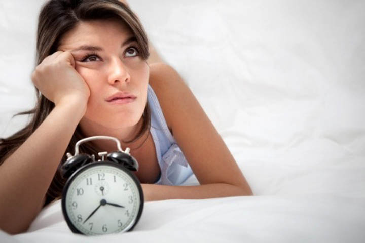 A beautiful woman is looking frustrated near a clock, wondering how much longer she needs to wait for her boyfriend.