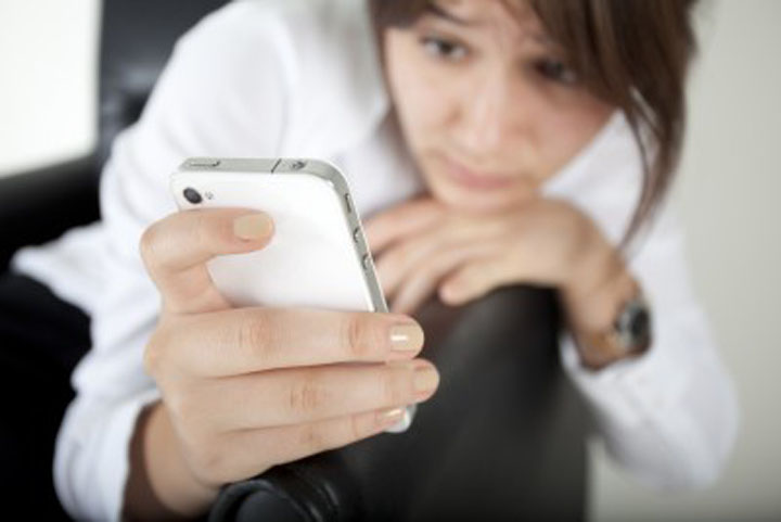 A woman looks at her phone wondering why he stopped texting.