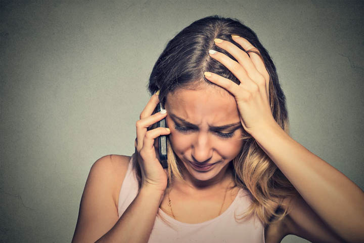 A woman is upset talking on her cell phone.