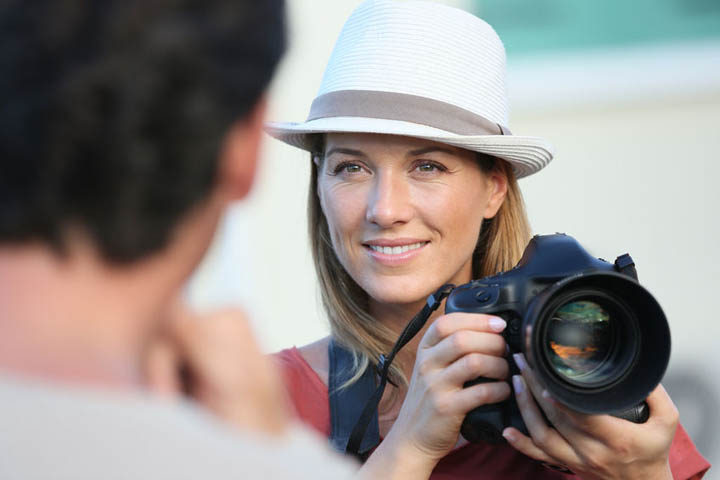 A beautiful woman with camera looking at a man.