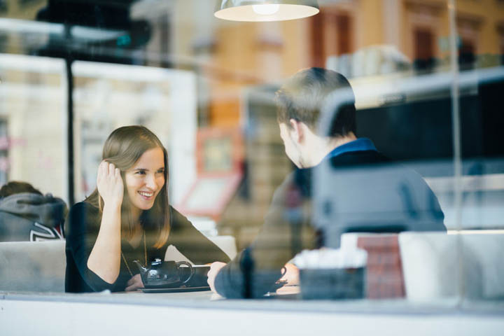 Young couple on a date talking in coffee shop