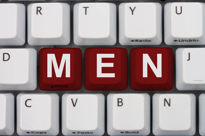 A gray computer keyboard with the word men in red letters