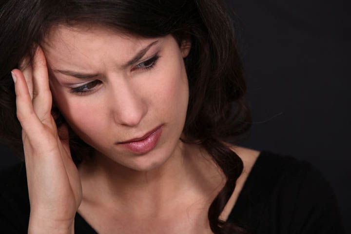 A woman rubs her head because she's confused wondering if he's into her or not.