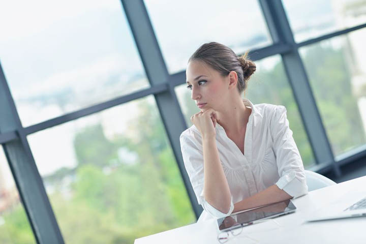 Portrait of young pretty woman sitting at a table wondering if no contact will work with her boyfriend.