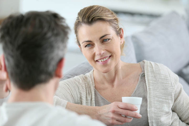 A mature couple on a date talking together in sofa