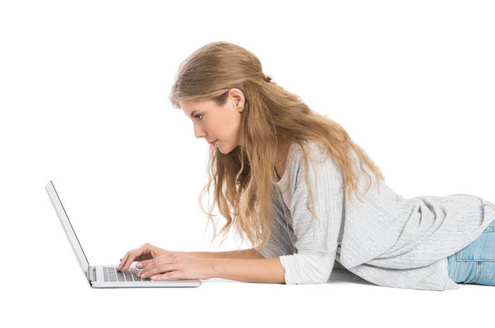 Woman lying on floor on a video call using laptop in a long distance relationship.