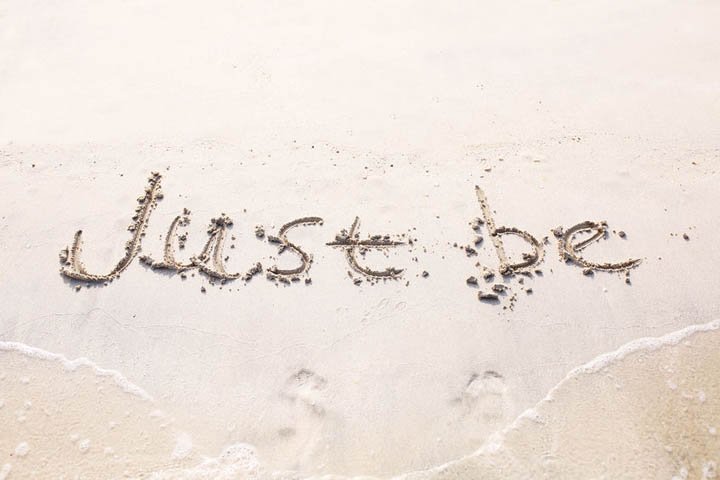 Words just be, written on sand of a beach.