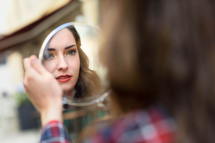 Beautiful woman looking into a mirror.