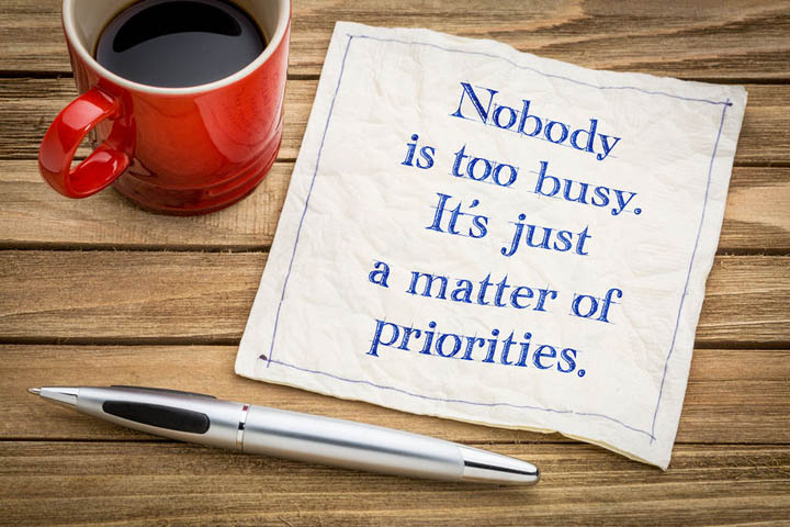 Nobody is too busy, it is a matter of priorities - handwriting on a napkin with a cup of espresso coffee