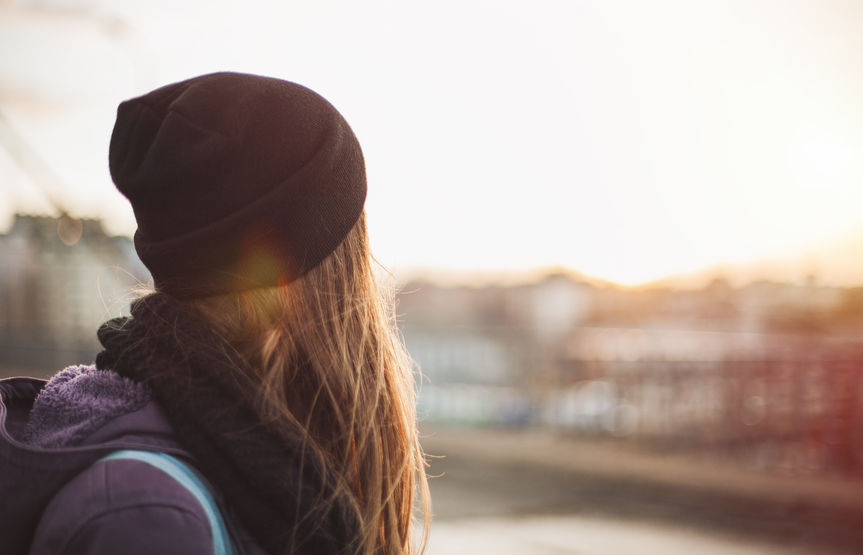 sad woman walking on the city street at sunset